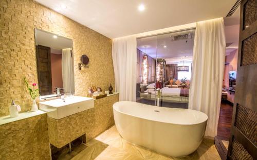 ein Badezimmer mit einer großen Badewanne und einem Waschbecken in der Unterkunft Rose Garden Hotel in Yangon