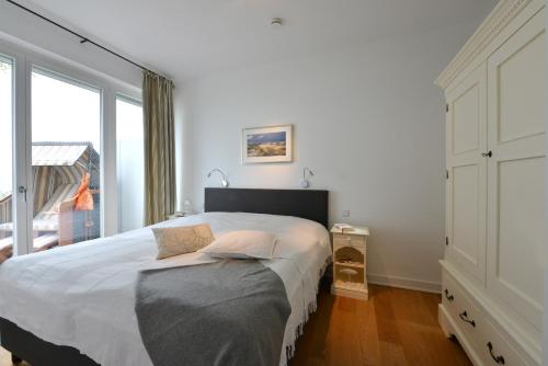 ein Schlafzimmer mit einem großen Bett und einem großen Fenster in der Unterkunft Ferienwohnung Silbermöwe in Sassnitz