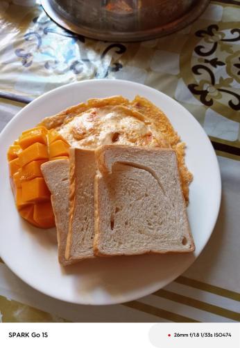 a white plate with a slice of bread and a pie at golden anchor lodge in Coron