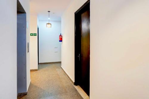 an empty hallway with a black door and a hallwayngth at Collection O Sector 53 Golf Course Road in Gurgaon