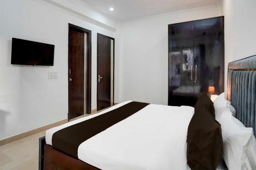 a bedroom with a white bed and a flat screen tv at Collection O Sector 53 Golf Course Road in Gurgaon