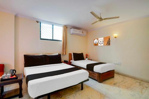 a bedroom with two beds and a ceiling fan at Collection O Civil Aviation HAL Road in Bengaluru
