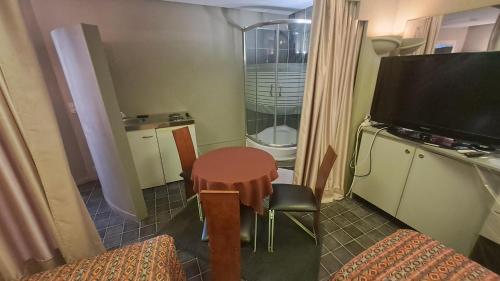 a small room with a small table and a television at BeautyD Triple Room with double bed and 1 folding bed in Gullegem