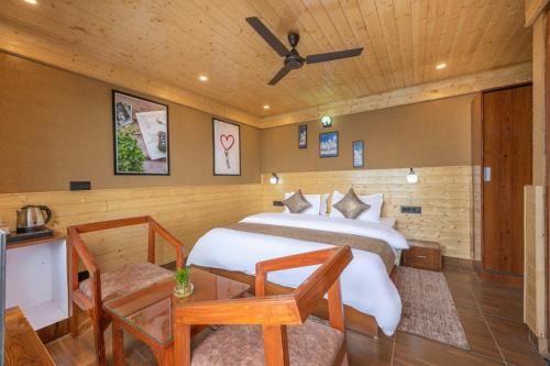a bedroom with a bed and a table and chairs at Countryside Boutique Hotel in Shimla