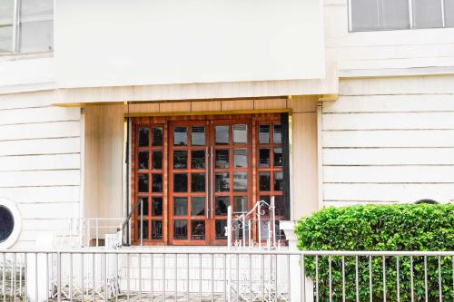 a wooden door on a building with a fence at Collection O Vashi formerly Blue Diamond in Turambhe