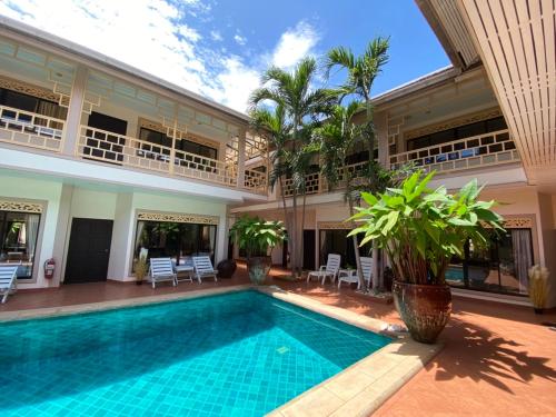 a villa with a swimming pool and a building at The Elite Resort Pattaya in Pattaya South