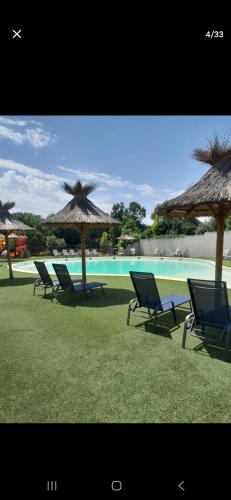 un groupe de chaises et de parasols à côté d'une piscine dans l'établissement Chalet confort et détente, à La Celle-sous-Gouzon