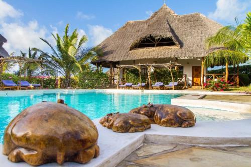two turtle statues in front of a swimming pool at Kipepeo Residence in Malindi