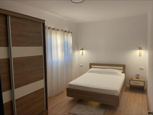 a bedroom with a bed and a sliding glass door at EverGreen Escape in Berat in Berat