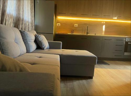 a living room with a couch and a kitchen at EverGreen Escape in Berat in Berat