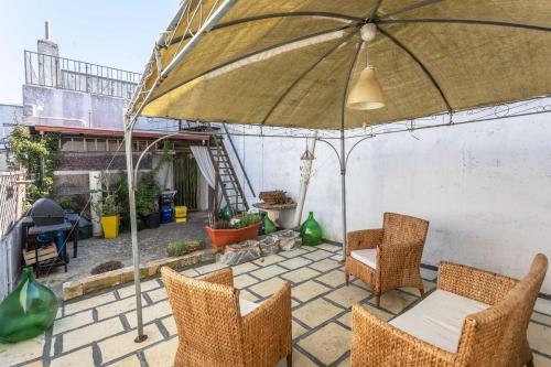 Un patio con una mesa y sillas y una sombrilla. en Dimora Enea con idromassaggio -Salento Reservation, en Ugento