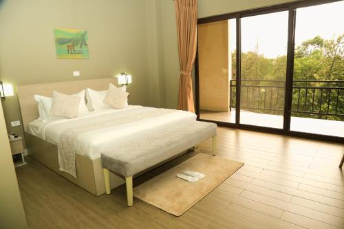 a bedroom with a large bed and a balcony at Haile Resort Jimma in Jīma