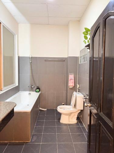 a bathroom with a toilet and a tub and a sink at Four P Home - Binh Thanh in Ho Chi Minh City