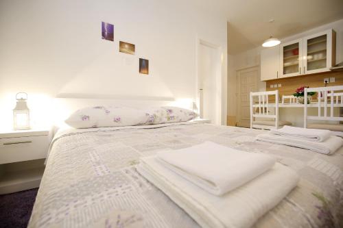 une chambre blanche avec un lit avec des serviettes dessus dans l'établissement Studio Apartment Laura, à Zadar