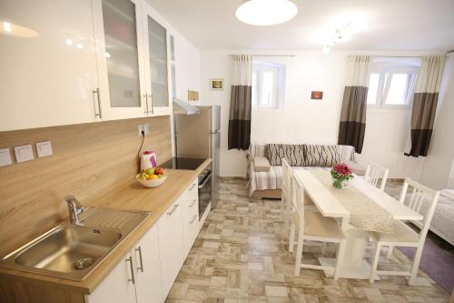 une cuisine et un salon avec un évier et une table dans l'établissement Studio Apartment Laura, à Zadar