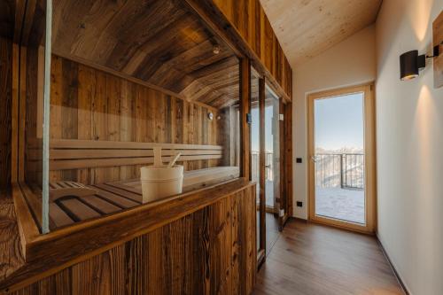 a room with wooden walls and a large window at Sonna Hüsli Lodge in Tschagguns