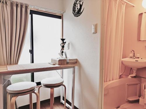 a bathroom with a table and stools and a sink at Moon Hotel in Tokyo