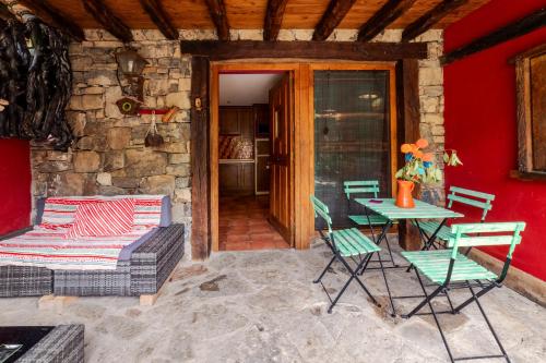 a patio with a table and chairs and a couch at Apartamentos Rurales & Spa La Bárcena in Enterria