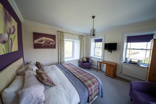 a bedroom with a bed and a couch in it at Two Harbours Guest House in Scalpay