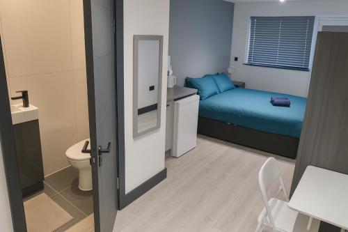 a small bathroom with a bed and a toilet at 12 London Deluxe Studios in Streatham Vale