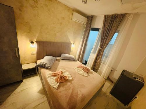 a bedroom with a bed with two bows on it at Ama Boutique in Constanţa