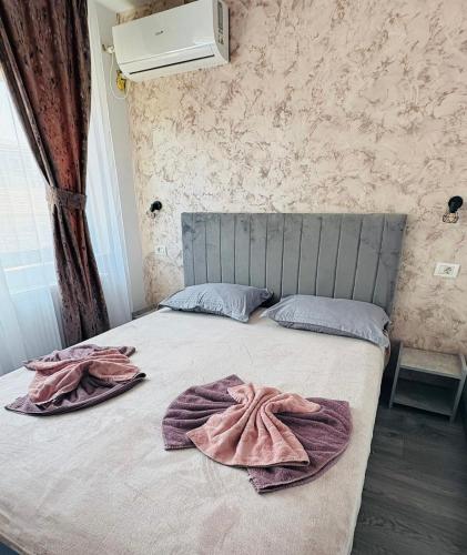 a bed with pink towels on top of it at Ama Boutique in Constanţa