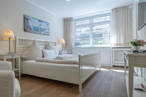 Una habitación blanca con una cama y una ventana. en fewo1846 - Residence Museumsberg - luxuriöse Wohnung mit 2 Schlafzimmern und 2 Bädern, en Flensburg