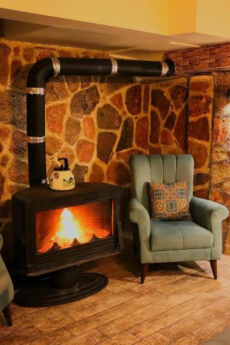 a living room with a fireplace and a chair at Odunpazarı Paşa Konak Hotel in Eskisehir