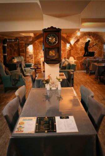 a table with a clock on it in a restaurant at Odunpazarı Paşa Konak Hotel in Eskisehir