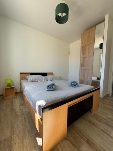 - une chambre avec un grand lit et des serviettes bleues dans l'établissement Maison neuve vue sur l'ancien moulin du Médoc, à Lesparre-Médoc