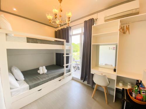 a room with bunk beds with a desk and a chair at Ronina's Sipocot Hotel in Sipocot
