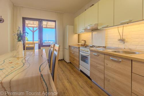 a kitchen with a table and a sink and a stove at Gato in Novalja