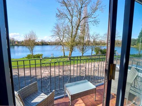 a balcony with a view of a lake from a door at Lakeview House 2x Hot Tub & Games Room in York