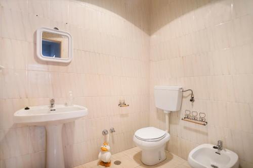 a bathroom with a toilet and a sink at Apartamento Vista Baia in São Martinho do Porto