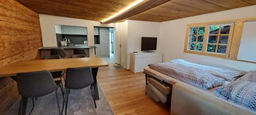 a bedroom with a bed and a table and chairs at Chalet Bernadette in Mörel