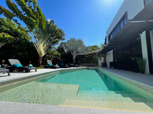 a swimming pool in the backyard of a house at Célèbre VILLA VENUS Playacar - 24 Pax in Playa del Carmen