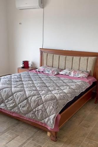 a bedroom with a large bed with a wooden frame at Villa climatisée piscine privée in Toudja