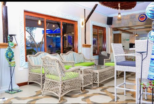 a group of wicker chairs and a table on a porch at Miugu Village Hotel in Murangʼa