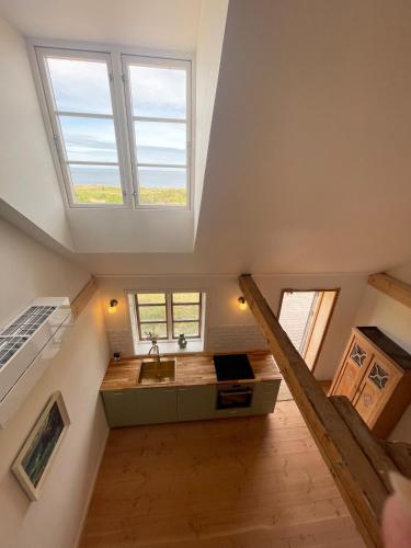 an attic bathroom with a sink and two windows at Wildernest Bornholm - Svanen in Neksø