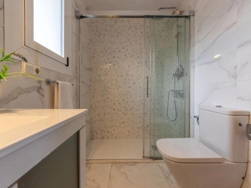 a bathroom with a toilet and a glass shower at POSIDONIA - Espectaculares vistas al mar in L'Ampolla