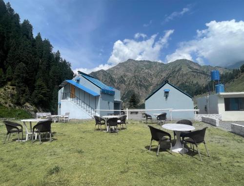 un groupe de tables et de chaises devant un bâtiment dans l'établissement Al Najm Resorts, à Nārān