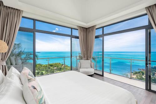 a bedroom with a large bed and large windows at Villa Seawadee - luxurious, award-winning design Villa with amazing panoramic seaview in Chaweng Noi Beach