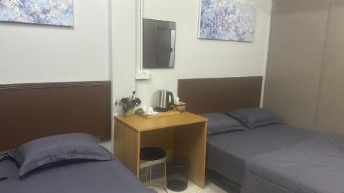a room with two beds and a desk with two beds at MDF Payang Guest House in Kuala Terengganu