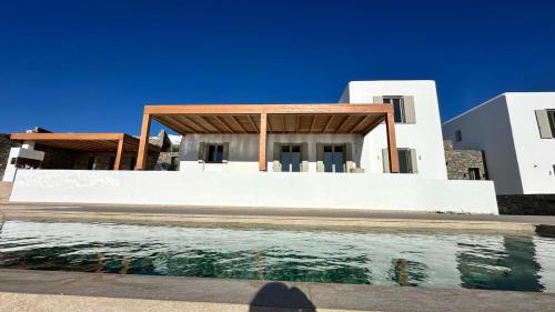 a house with a swimming pool in front of a house at Asana 1 in Márpissa