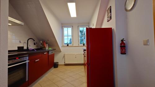 a kitchen with a red refrigerator in a room at alte Bäckerei Ottendorf-Okrilla #Robert# im Norden von Dresden, WLan, Netfix in Ottendorf-Okrilla