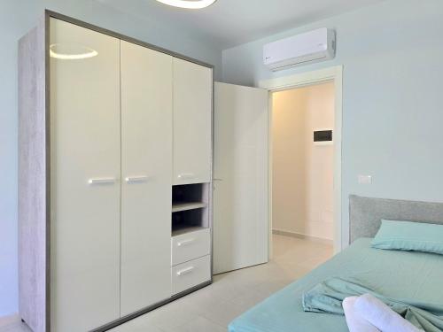 a bedroom with white cabinets and a bed at San Pietro Happy Stay 280 in Lalzit Bay