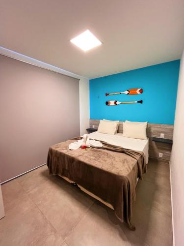 a bedroom with a large bed with a blue wall at Fontes da Pipa by Liiv in Pipa