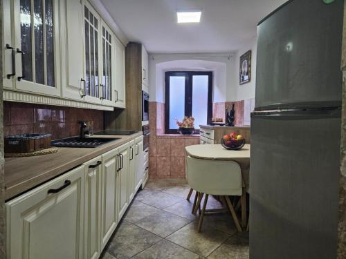 a kitchen with a refrigerator and a table in it at Athos Guesthouse in Kotor