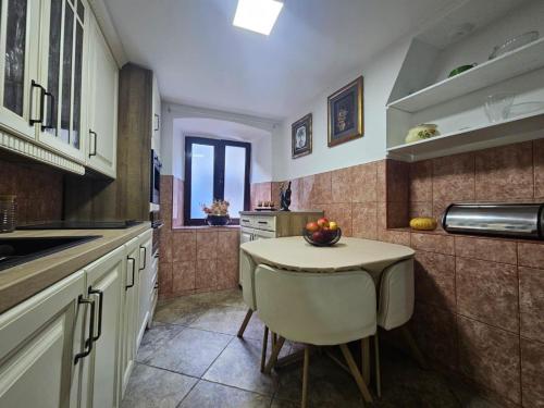 a kitchen with a small table with a bowl of fruit on it at Athos Guesthouse in Kotor