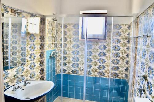 bagno piastrellato blu con lavandino e doccia di Casa do Afonso a Sagres